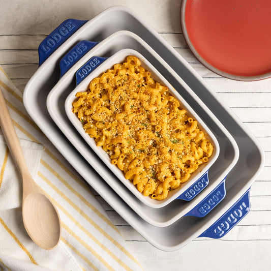 Macaroni and cheese in a set of nested baking dishes with 'Lodge' branding.