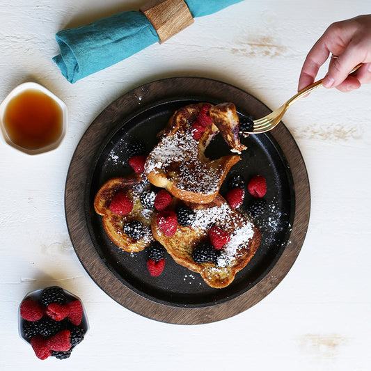 Someone eating french toast from serving griddle.
