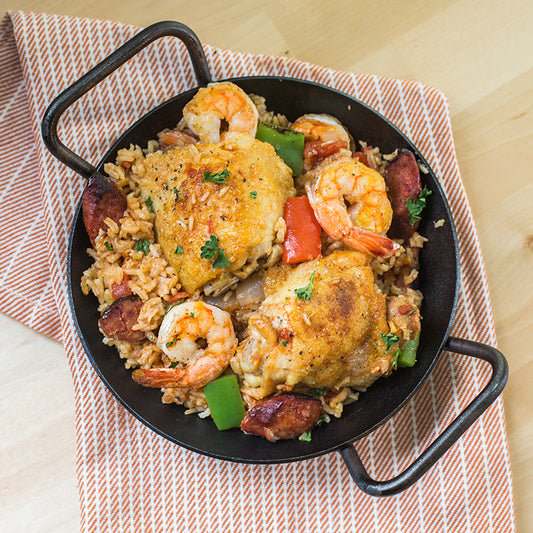 Freshly prepared chicken, shrimp, and rice served in pan.