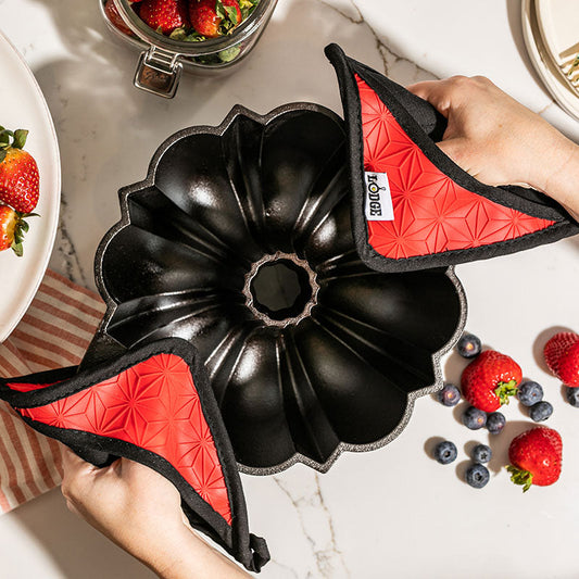 Someone lifting pan with potholders.