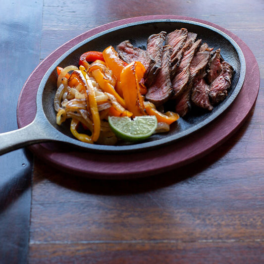 Steak fajitas served with skillet and underliner.