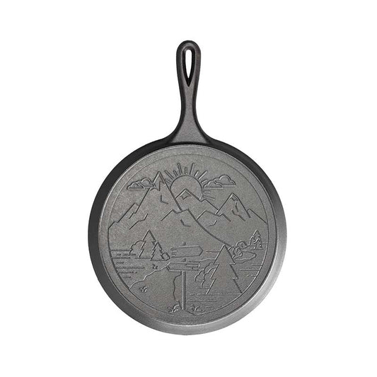 Round griddle with an engraved mountain design on the back.
