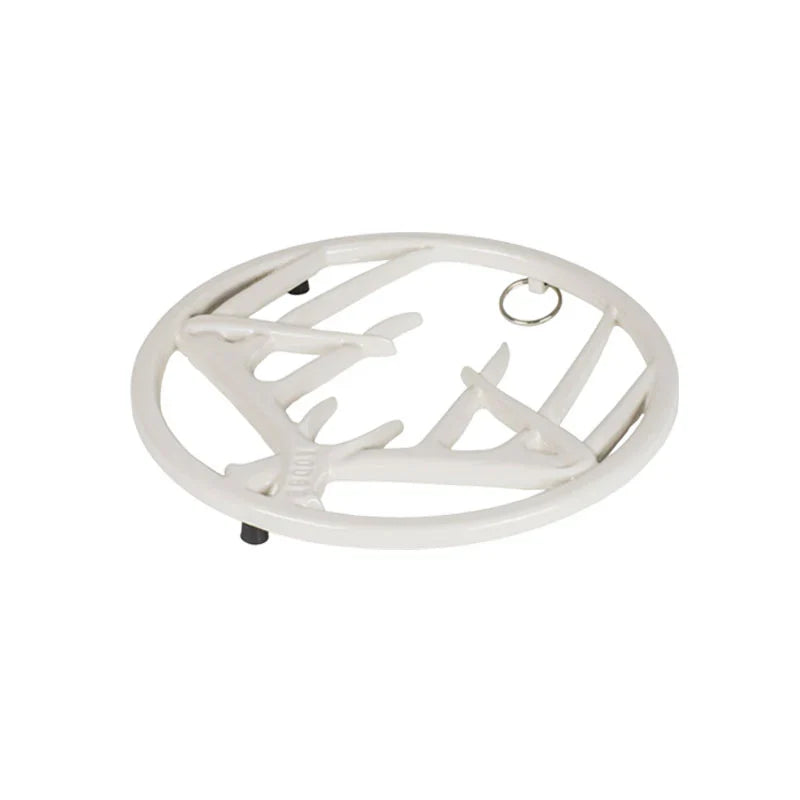 White enamel trivet with decorative antler design on a white background