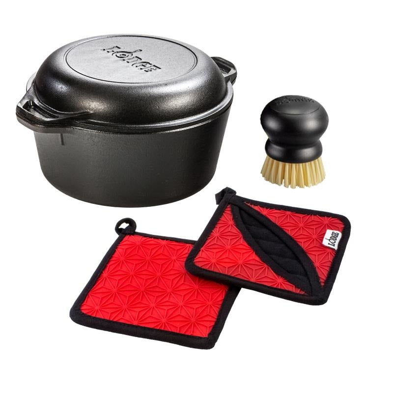 Set featuring the double dutch oven, round0black scrub brush, and two silicone-and-fabric potholders.