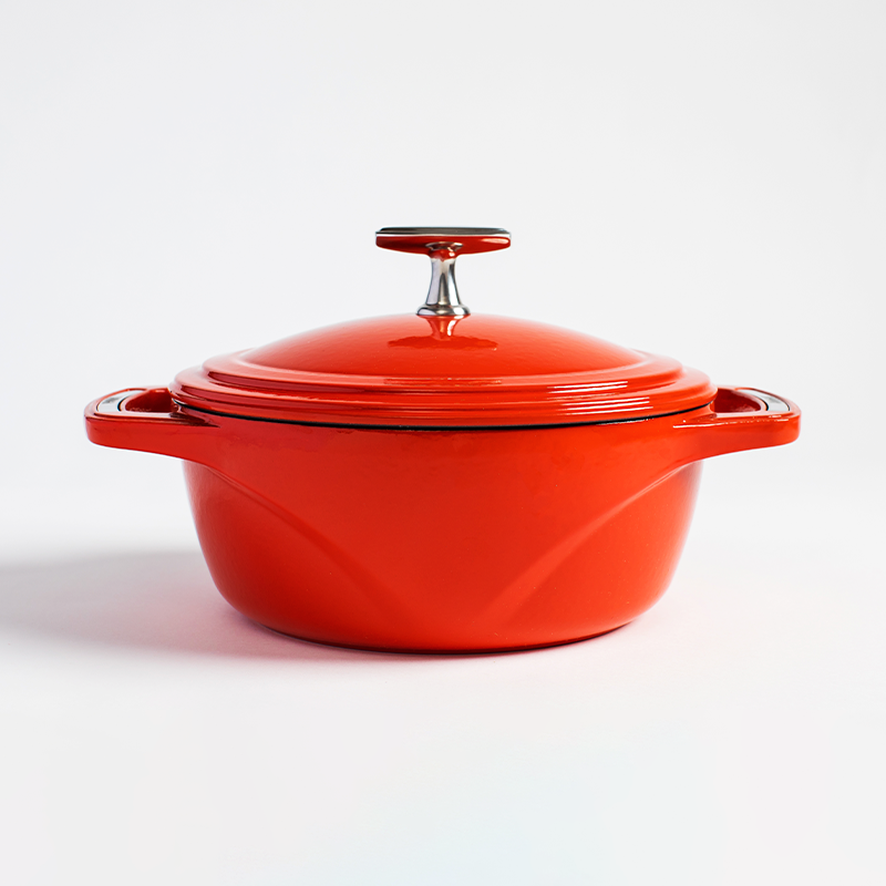Red enameled cast iron Dutch oven with a lid on a white background