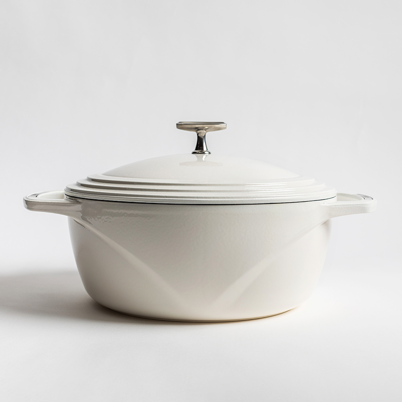 White enameled cast iron Dutch oven with a lid on a white background