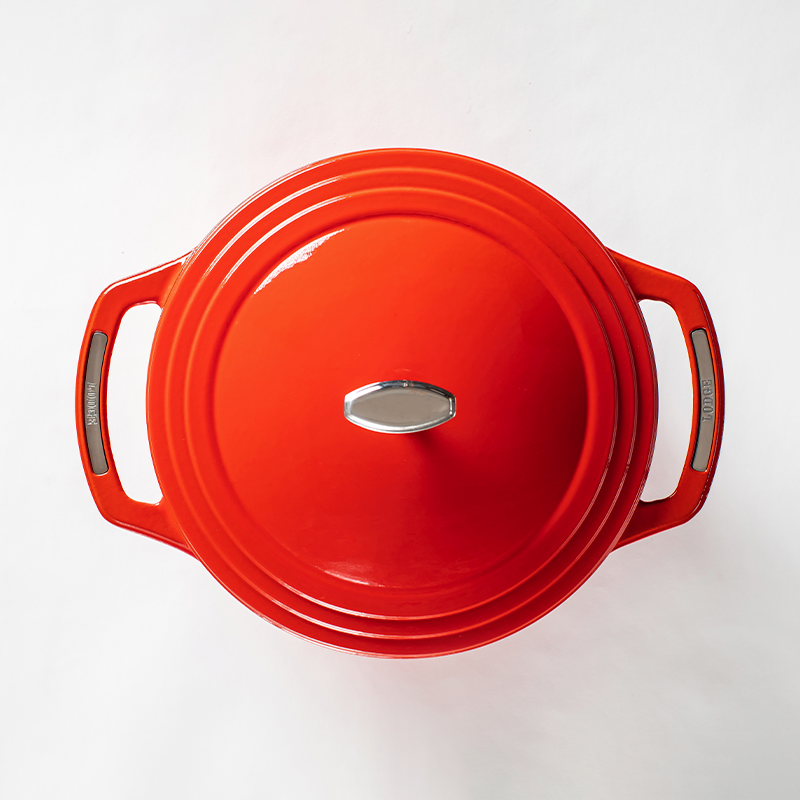 Top of red dutch oven lid with silver lid knob and silver accents on handles.