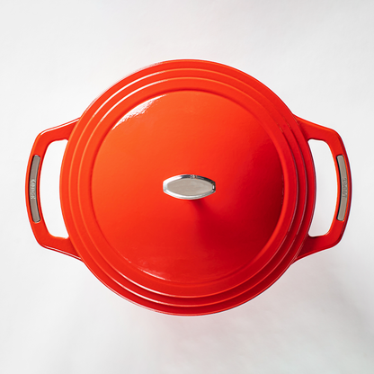 Top of red dutch oven lid with silver lid knob and silver accents on handles.