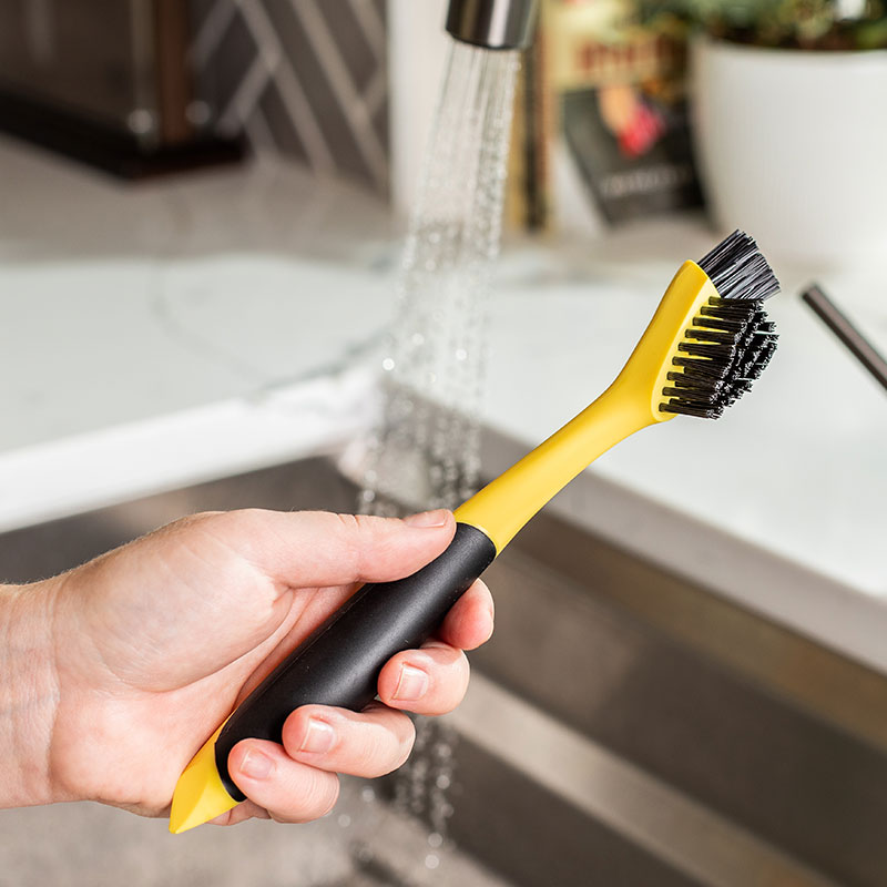 Someone holding brush in sink.