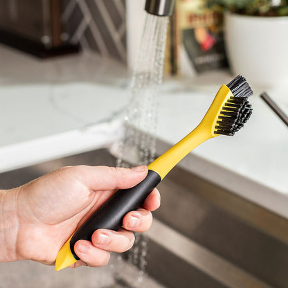 Someone holding brush in sink.