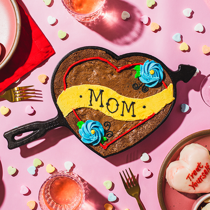 Baked brownie with mom themed icing on a Valentine's day background.