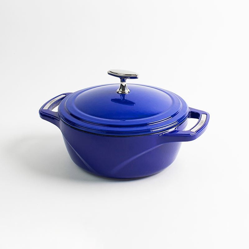 Blue enameled cast iron Dutch oven with a lid on a white background