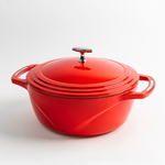 Red enameled cast iron Dutch oven with a lid on a white background