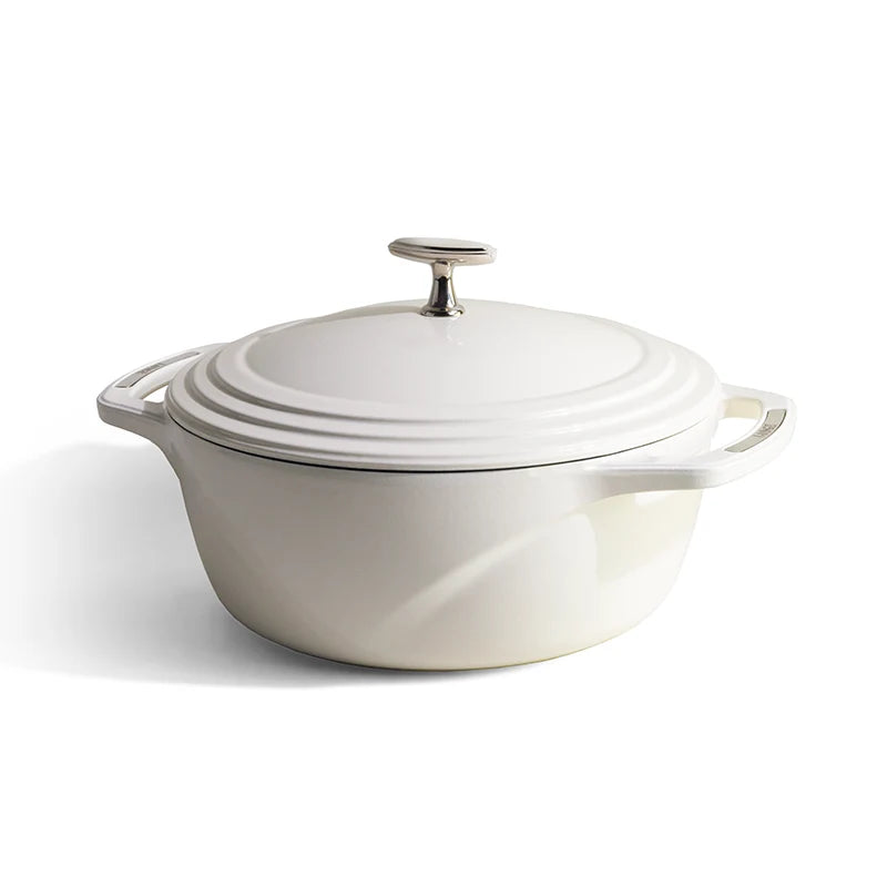 White enameled cast iron Dutch oven with a lid on a white background