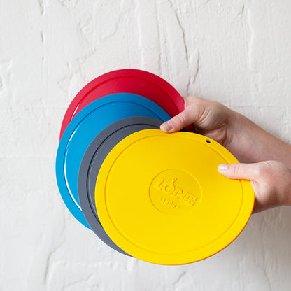 Someone holding all 4 color options; red, blue, grey, and yellow.