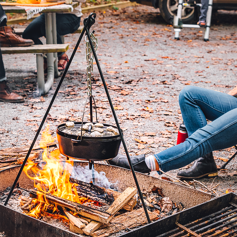 Tripod being used to hold dutch oven over fire.