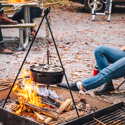 Tripod being used to hold dutch oven over fire.