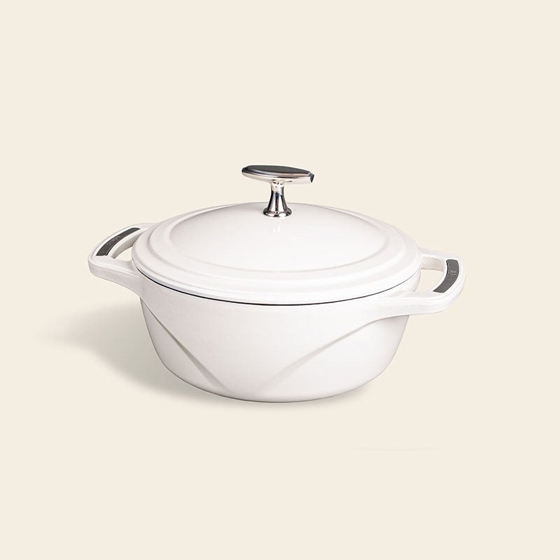 White enameled cast iron Dutch oven with a lid on a white background