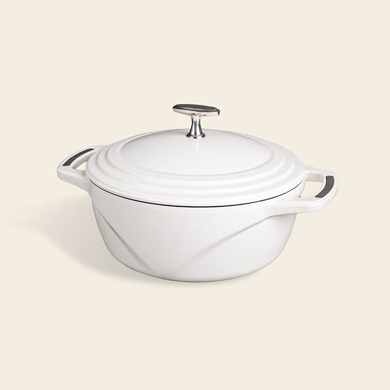 White enameled cast iron Dutch oven with a lid on a white background