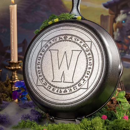 Cast iron skillet in a fantasy setting with flowers and a candle.