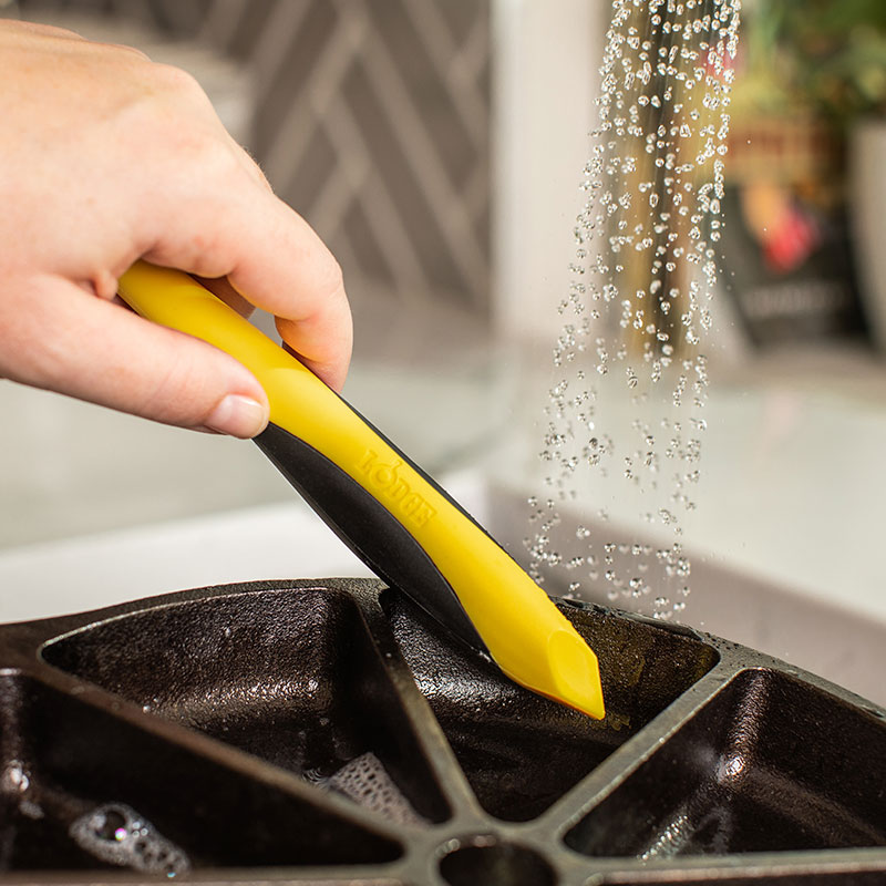 Someone using the pointed end of brush as a scraper.