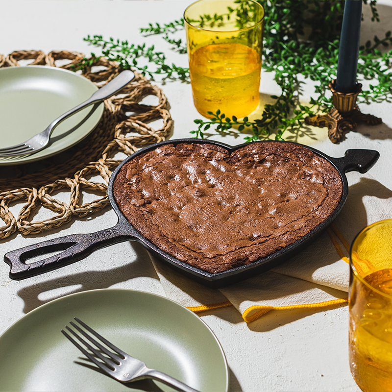 Freshly baked brownie in heart shaped skillet.