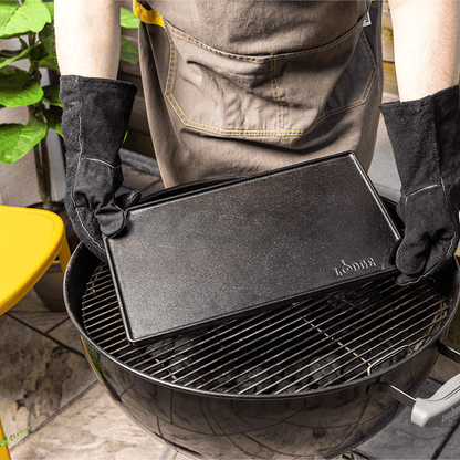 A person placing griddle on charcoal grill.