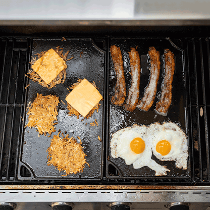 Grill with hash browns, cheese, sausages, and eggs cooking on griddle.