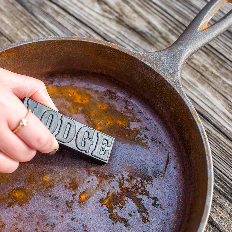 Someone using eraser to remove rust from skillet.