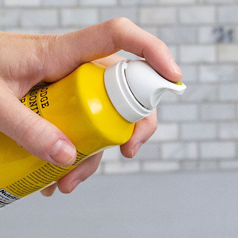 Close-up of someone spraying the hold by pressing a button on top.