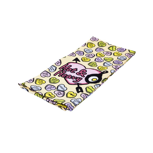 Dish towel with conversation heart pattern, with a large heart on center front saying "Hot & Heavy" and smaller hearts scattered throughout saying "sizzle SZN", "Treat yourself", "You're sweet" and more.