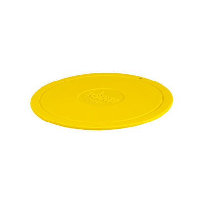 Yellow circular trivet with Lodge branding in center.