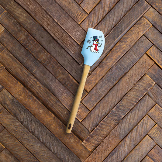 Spatula on wooden counter, featuring a snowman design on head.