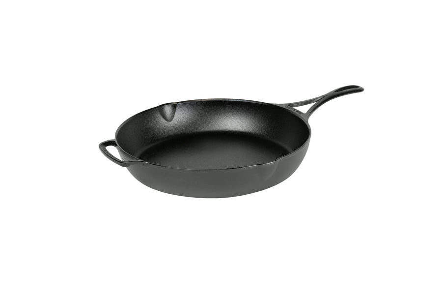A black, cast iron skillet with a long handle and a loop handle on other side, along with two pour spouts on opposite sides.