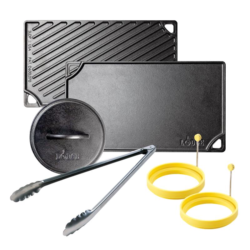 Set of cast iron griddle components including a grill press, tongs, and egg rings on a white background.