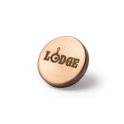 A round, copper colored knob engraved with the word 'LODGE'.