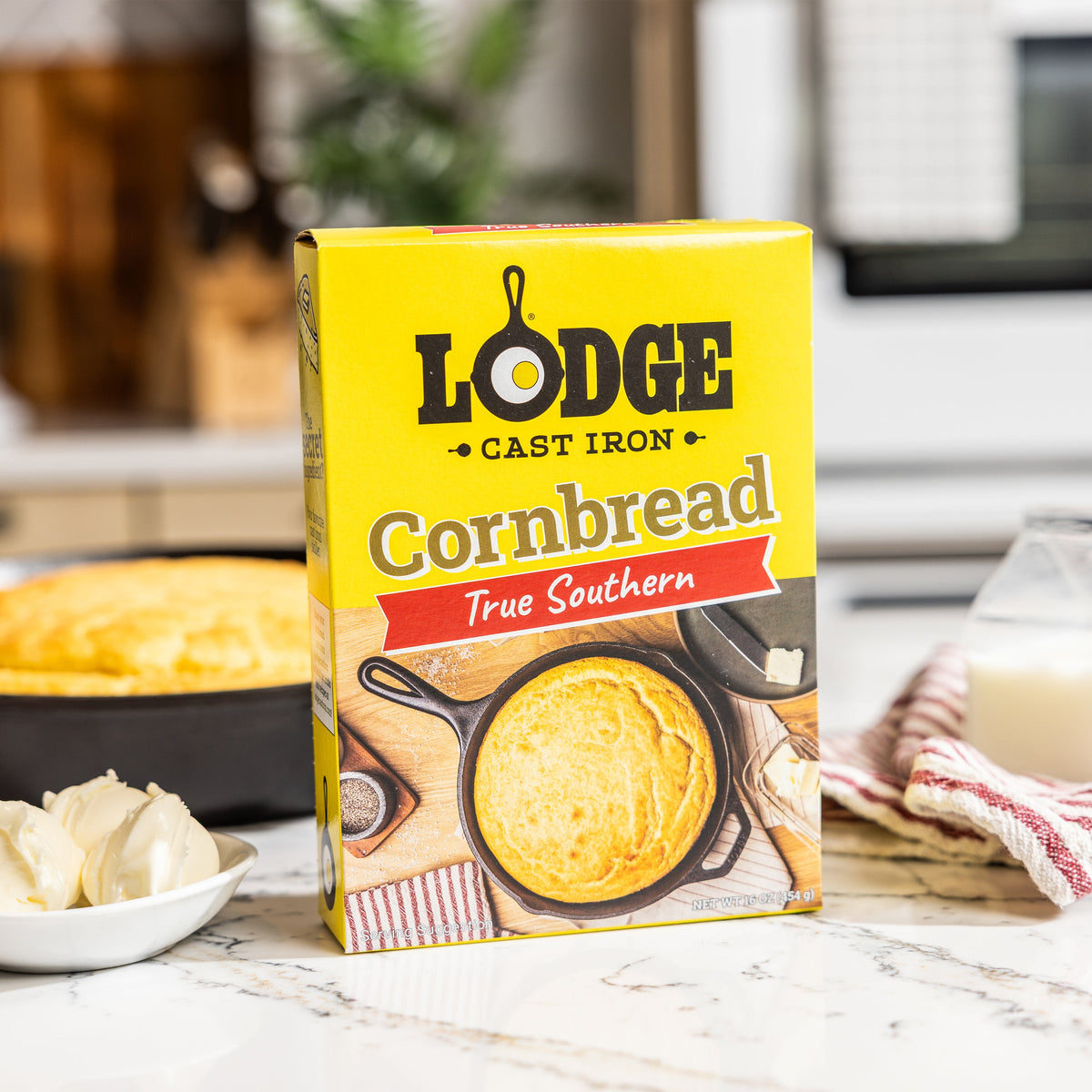 Lodge Cornbread mix box with cornbread and butter on a kitchen counter