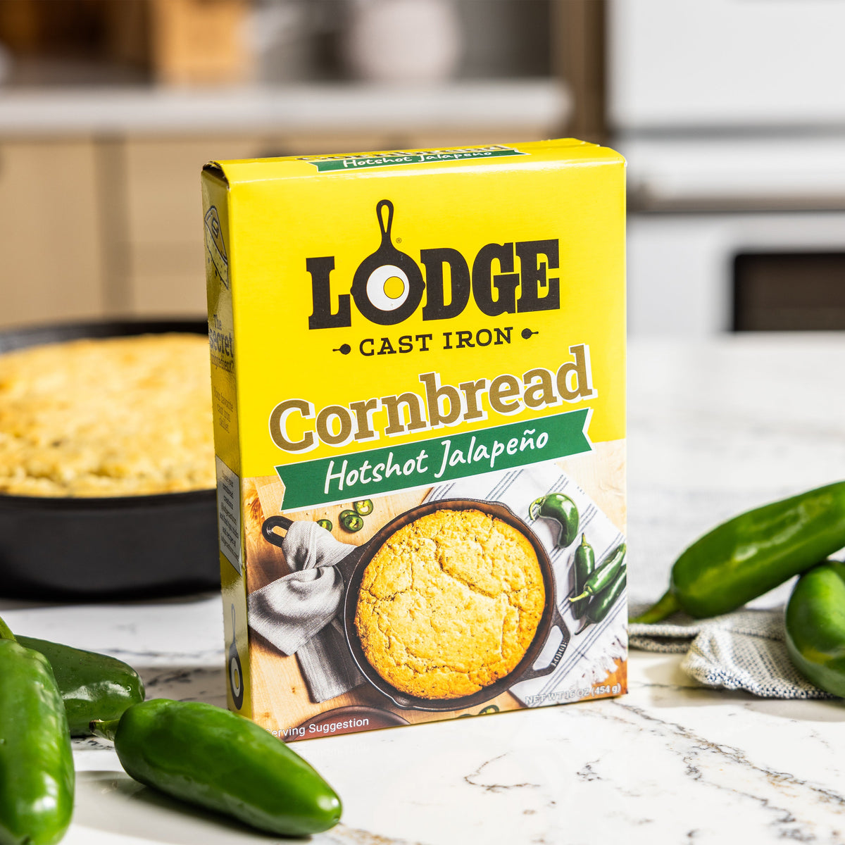 Lodge Cornbread Hotshot Jalapeño package with cornbread and jalapeños on a kitchen counter.