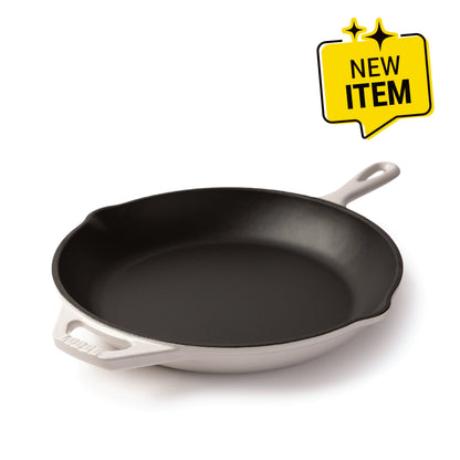 A Lodge enameled cast iron skillet with a black interior and a white exterior, shown on a white background with a yellow 'NEW ITEM' badge in the top right corner.