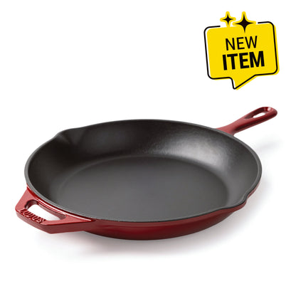 A Lodge enameled cast iron skillet with a black interior and a red exterior, shown on a white background with a yellow 'NEW ITEM' badge in the top right corner.