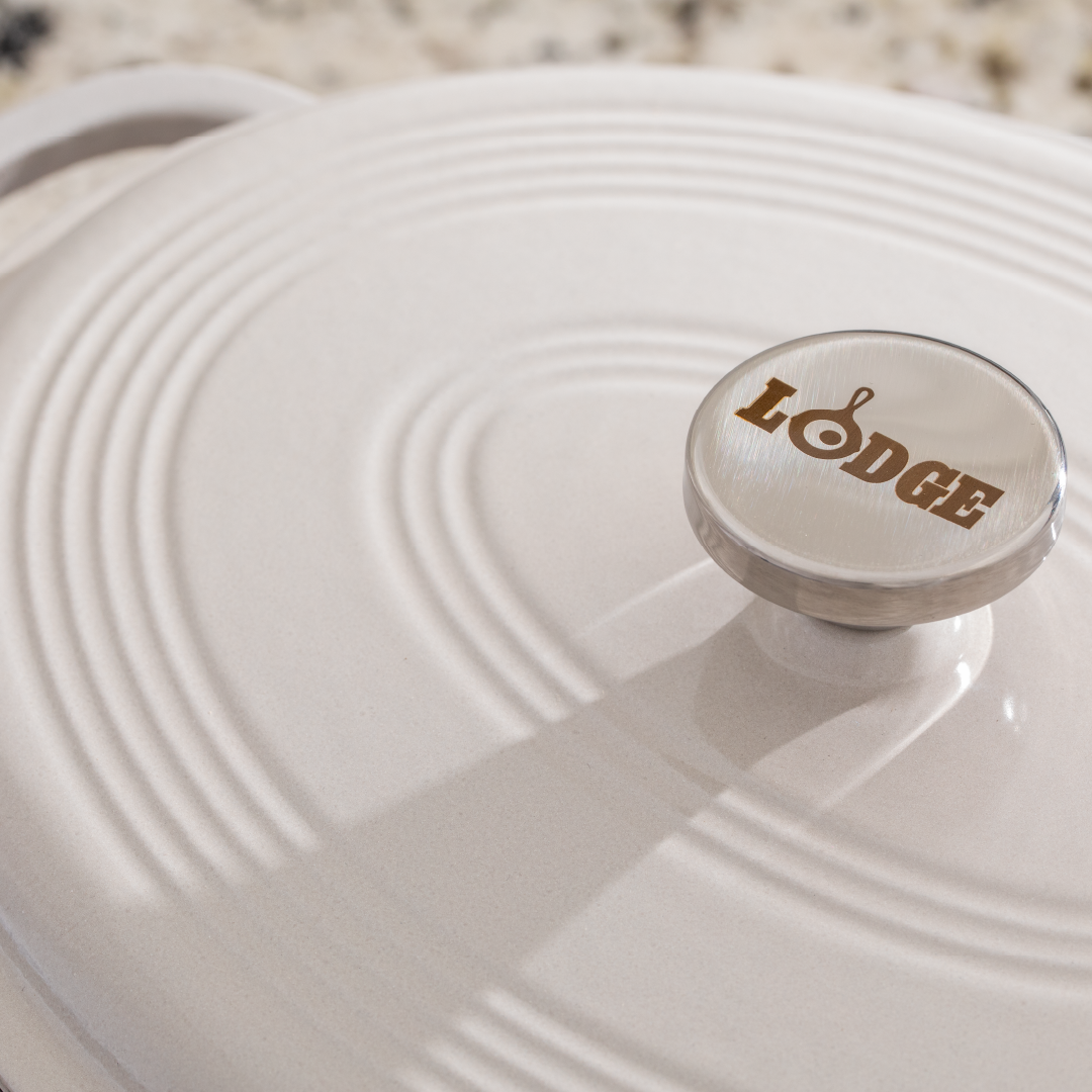 Close up of lid with silver knob containing Lodge branding.