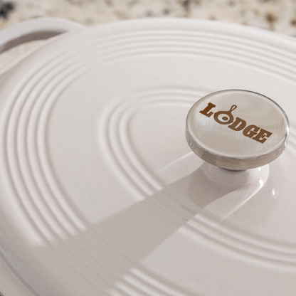 Close up of lid with silver knob containing Lodge branding.