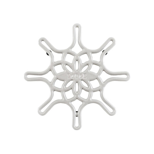 A white enameled cast iron trivet with a geometric snowflake-like pattern.