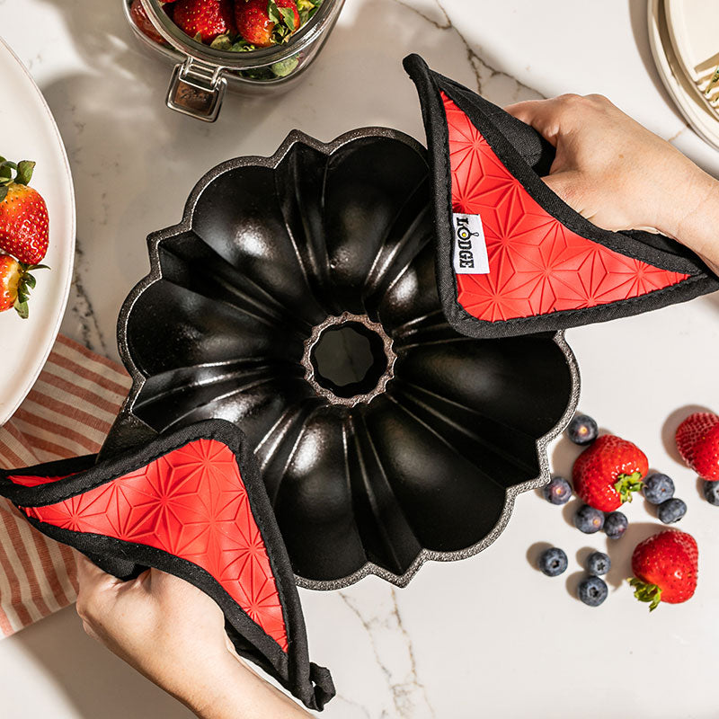 Someone lifting pan with potholders.