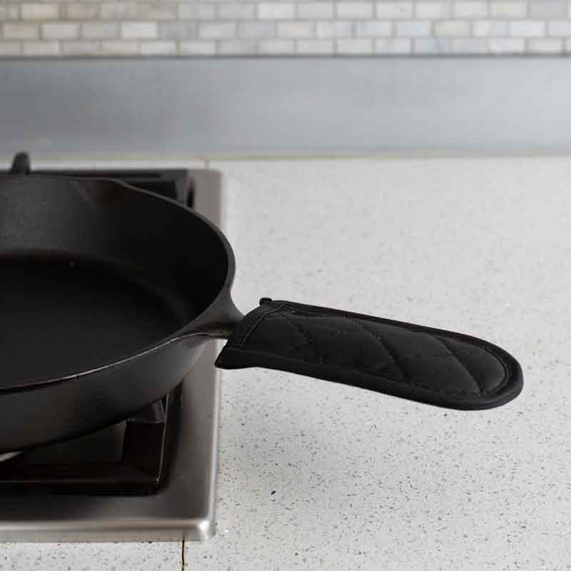 Handle holder being used on pan cooking on stove.