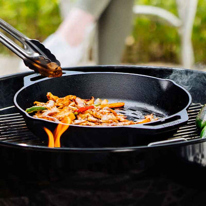 Someone using tongs to serve cooked dish from basket.