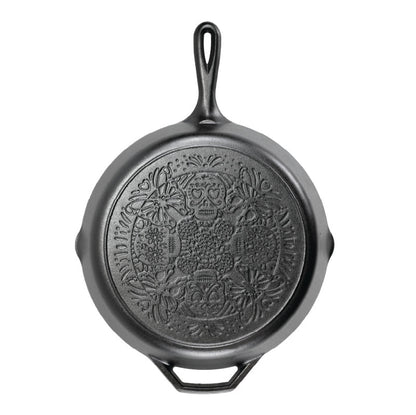 A black cast iron skillet with a butterfly sugar skull design on bottom of skillet.