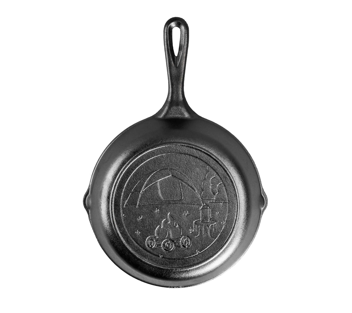 A cast iron skillet with an engraved campsite design on the back including a tent, campfire, and wooded area.