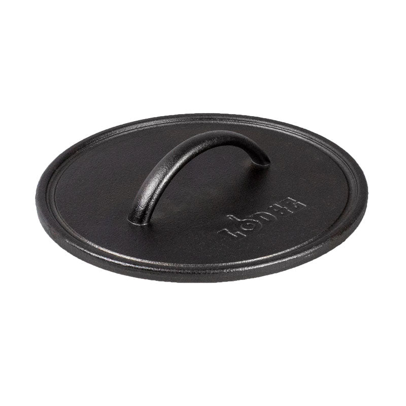 A black round seasoned cast iron grill press with a handle in the center.