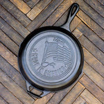 Black cast iron skillet with 'Made in America' and flag engraving on a wooden surface.